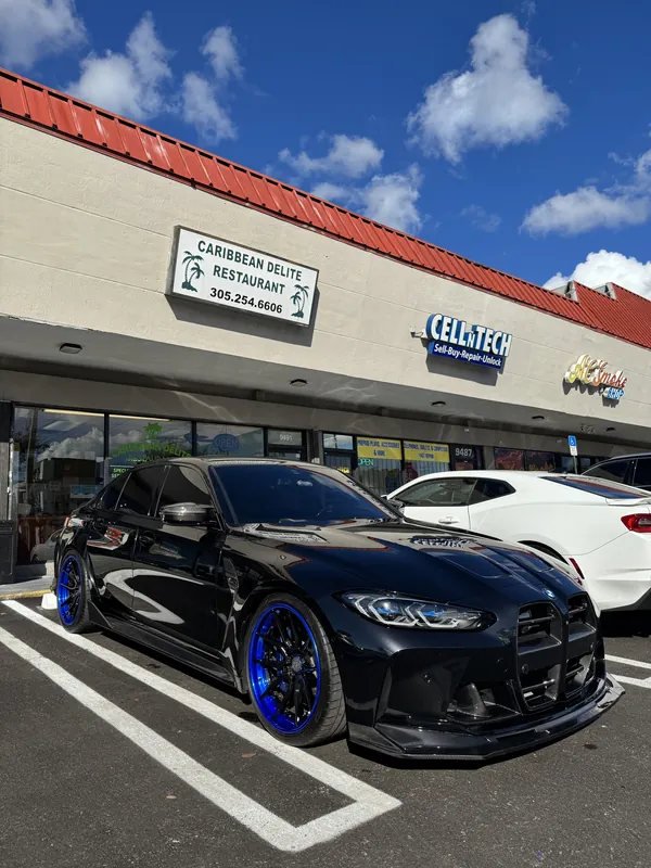 Black BMW M3 on blue wheels with glossy paint after mobile detailing