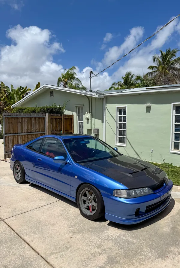 Blue Acura Integra coupe with carbon hood, freshly washed and detailed
